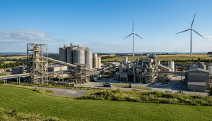 Steel and mining industrial site transitioning to clean energy with commercial wind turbines under a clear sky