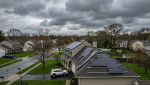 Solar panels on rooftop under cloudy sky illustrating weather dependency as a disadvantage of solar energy