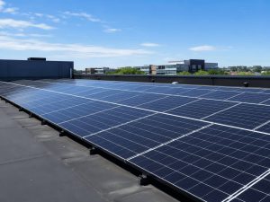 Monocrystalline solar panels installed on a dark rooftop