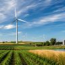 Wind energy in agriculture with wind turbines across open farmland and crop fields